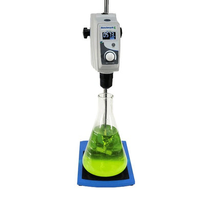 Lab beaker with green liquid being stirred by a digital stirrer on a white background
