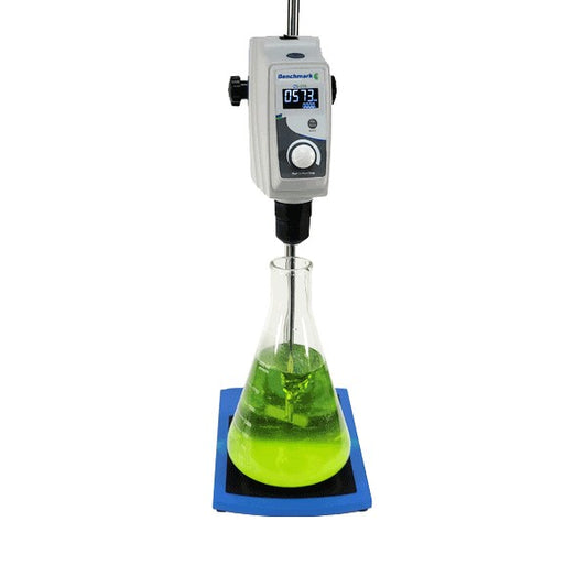 Lab beaker with green liquid being stirred by a digital stirrer on a white background